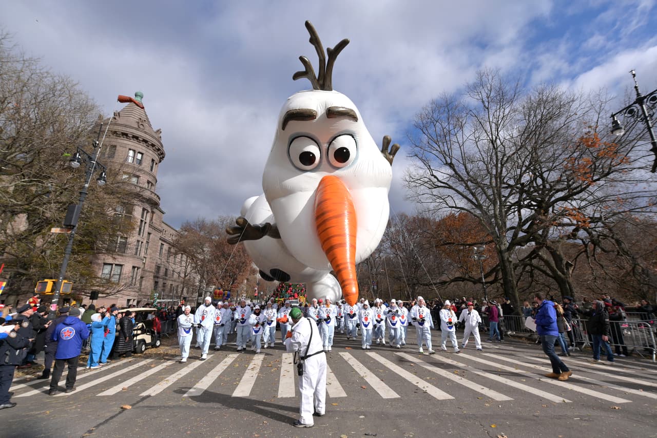 El muñeco de nieve Olaf de la película 'Frozen' abarca casi toda la calle escoltado por decenas de participantes del desfile.