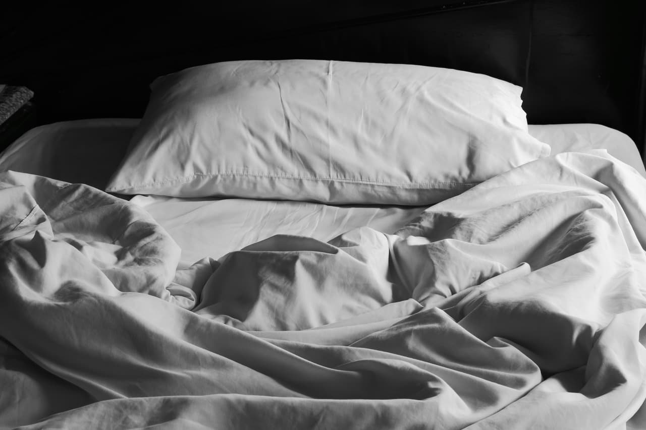 Messy white bed and pillow, in the morning