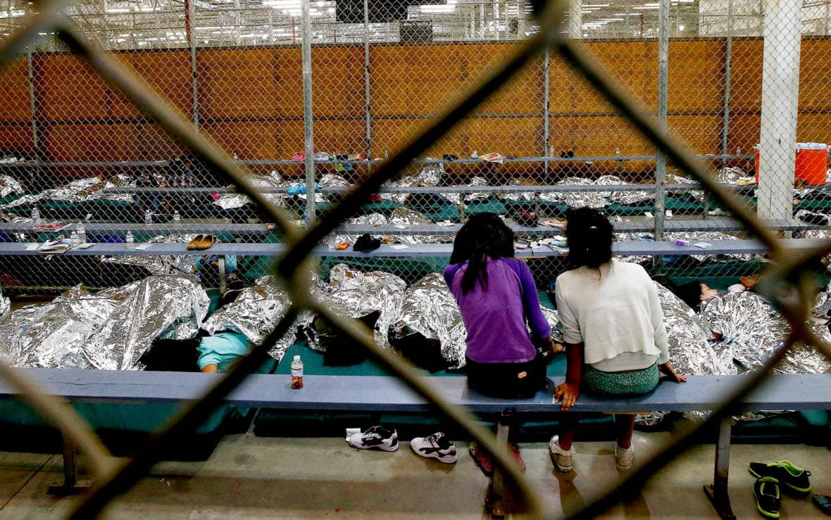 Two young girls sit in a holding area where hundreds of mostly Central American immigrant children were being processed and held at a U.S. Customs and Border Protection facility in 2014.
