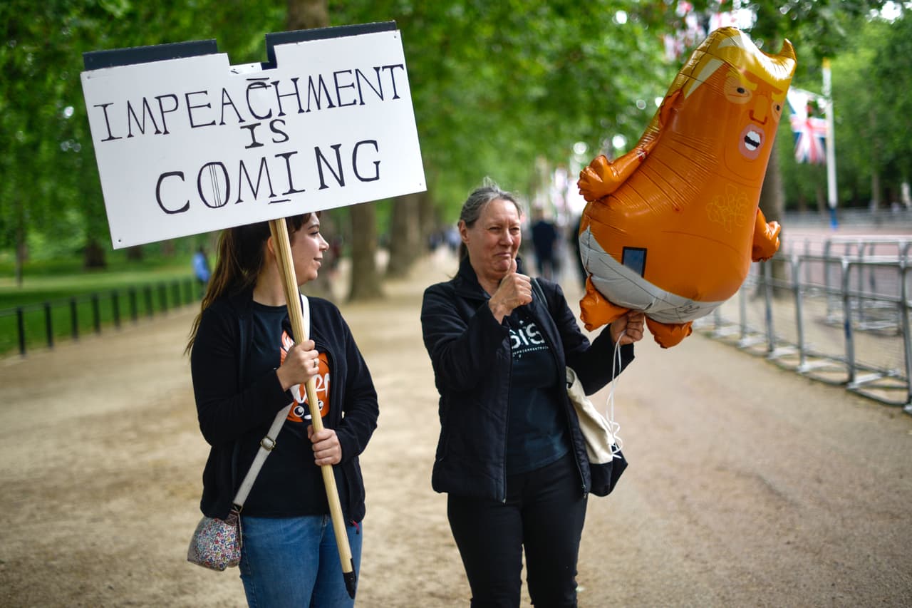“El juicio político se acerca”, se lee en la pancarta que lleva la manifestante de la izquierda en la foto. La de la derecha llevó a la protesta un pequeño ‘bebé Trump’ inflable.