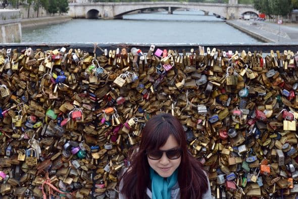 Lili, una turista de Macao posa frente al Puente de las Artes en Francia.