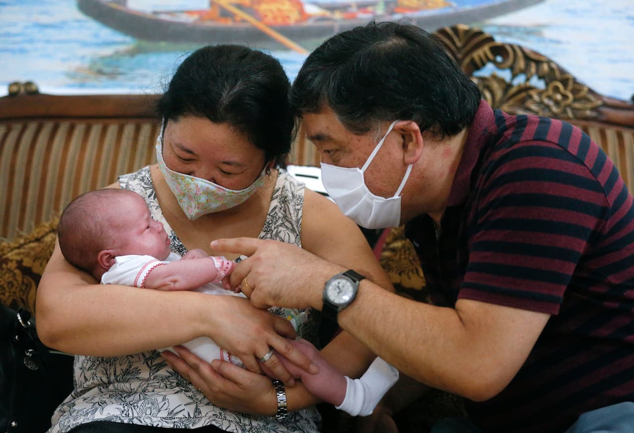 Claudia Arakari, de 52 años, y su esposo Osvaldo Nakandakare, de 55 años, llegaron de Buenos Aires, Argentina, a Ucrania para conocer a su bebé.
<b>Reaccionan llenos de emoción mientras sostienen por primera vez su niña, Soye, de una madre sustituta ucraniana a quien pudieron conocer después de semanas de cuarentena por el coronavirus. </b>Decenas de bebés quedaron 'varados' en la capial ucraniana por el cierre de fronteras por la pandemia.