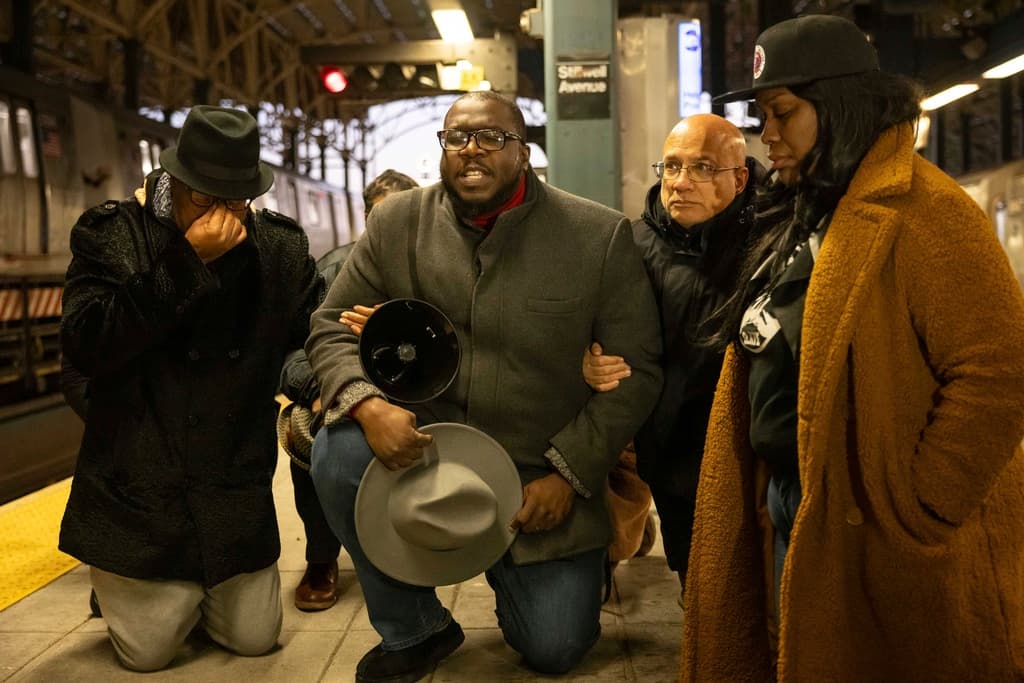 A los líderes de la comunidad de Coney Island y otras cercanas en Brooklyn, les inquieta que 
<b>cuatro días después del crimen</b> las autoridades 
<b>no han logrado identificar a la mujer que murió quemada</b>. Los restos quedaron en un estado que complica su identificación. El jueves 26 de diciembre, el reverendo Kevin McCall, al centro, 
<b>dirigió en oración a otros portavoces comunitarios desde la plataforma del tren F,</b> donde ocurrió la tragedia.
