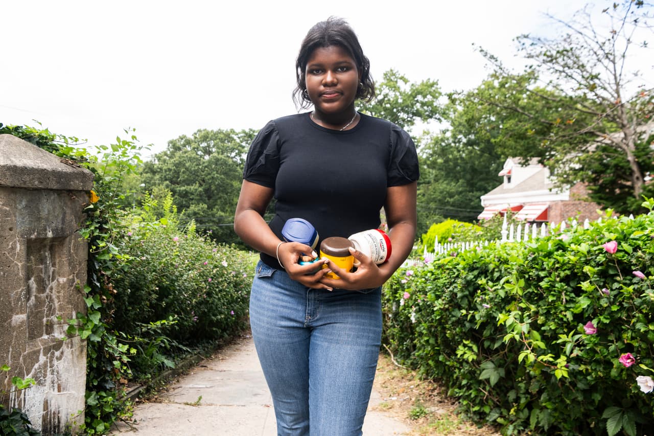 Mia Hall, de 14 años, posa para un retrato en el parque de su vecindario mientras sostiene algunos productos para el cuidado de la piel que usa habitualmente el jueves 29 de agosto de 2024, en el distrito del Bronx de Nueva York.
