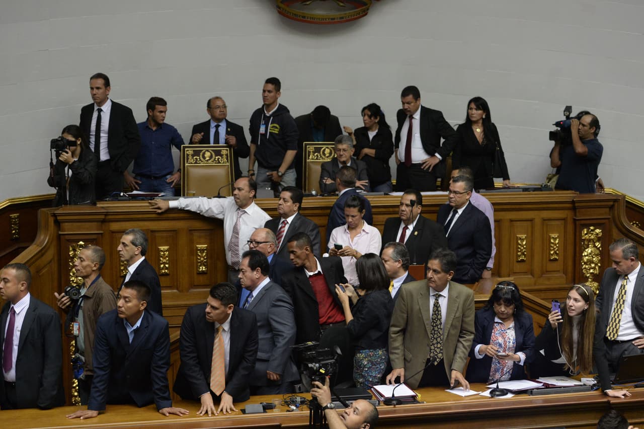 Algunos de los diputados de la mayoría opositora en la asamblea nacional de Venezuela se refugiaron en el podio, junto a la directiva del parlamento.