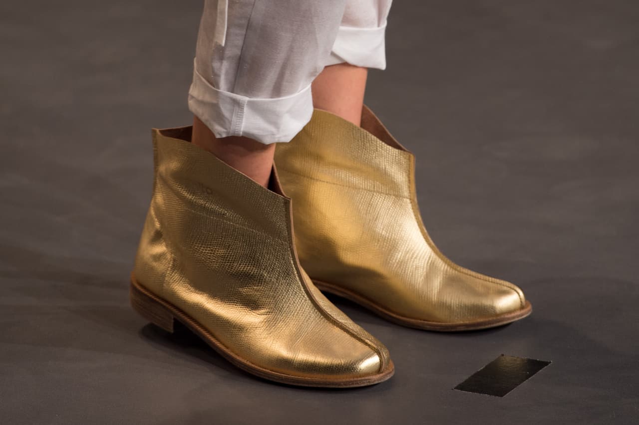 Si quieres alejarte de los botines tipo texanos de puntas muy alargadas puedes buscar unos de boca ancha, punta redonda y de colores metalizados. Pondrás toda la atención en tus pies. Imagínate unos dorados como estos, con unos mini short de jeans y una chamarra negra (con apliques dorados, por supuesto).