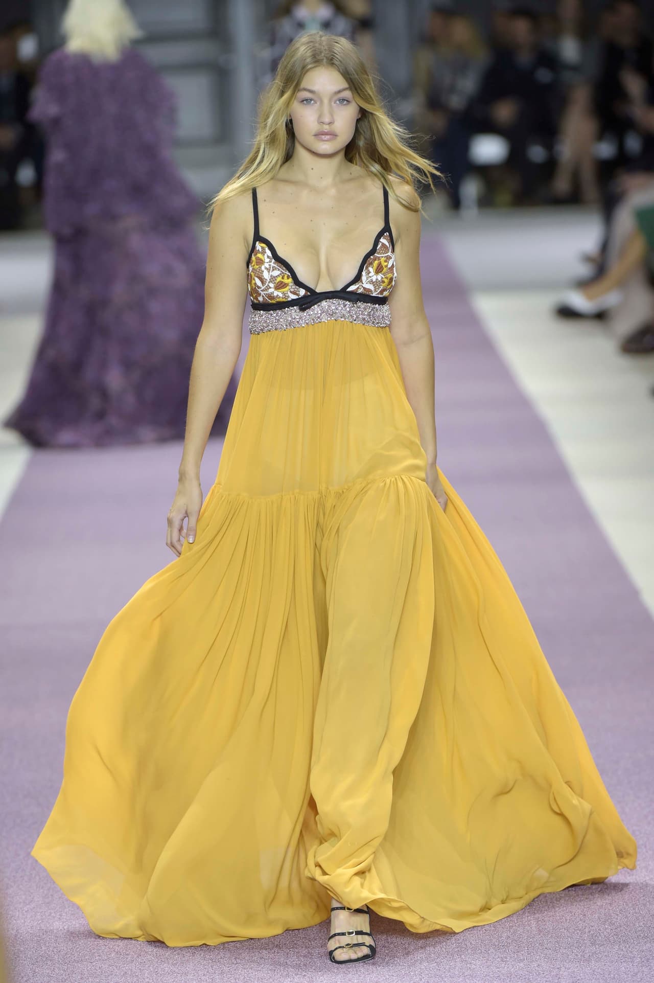 Luego de ser duramente criticada por algunos integrantes del mundo de la moda sobre las curvas de su cuerpo, Gigi se lució en un 'maxi dress' con cuello 'halter' y falda amplia amarilla del diseñador Giambatista Valli. ¡Checa cómo lució!