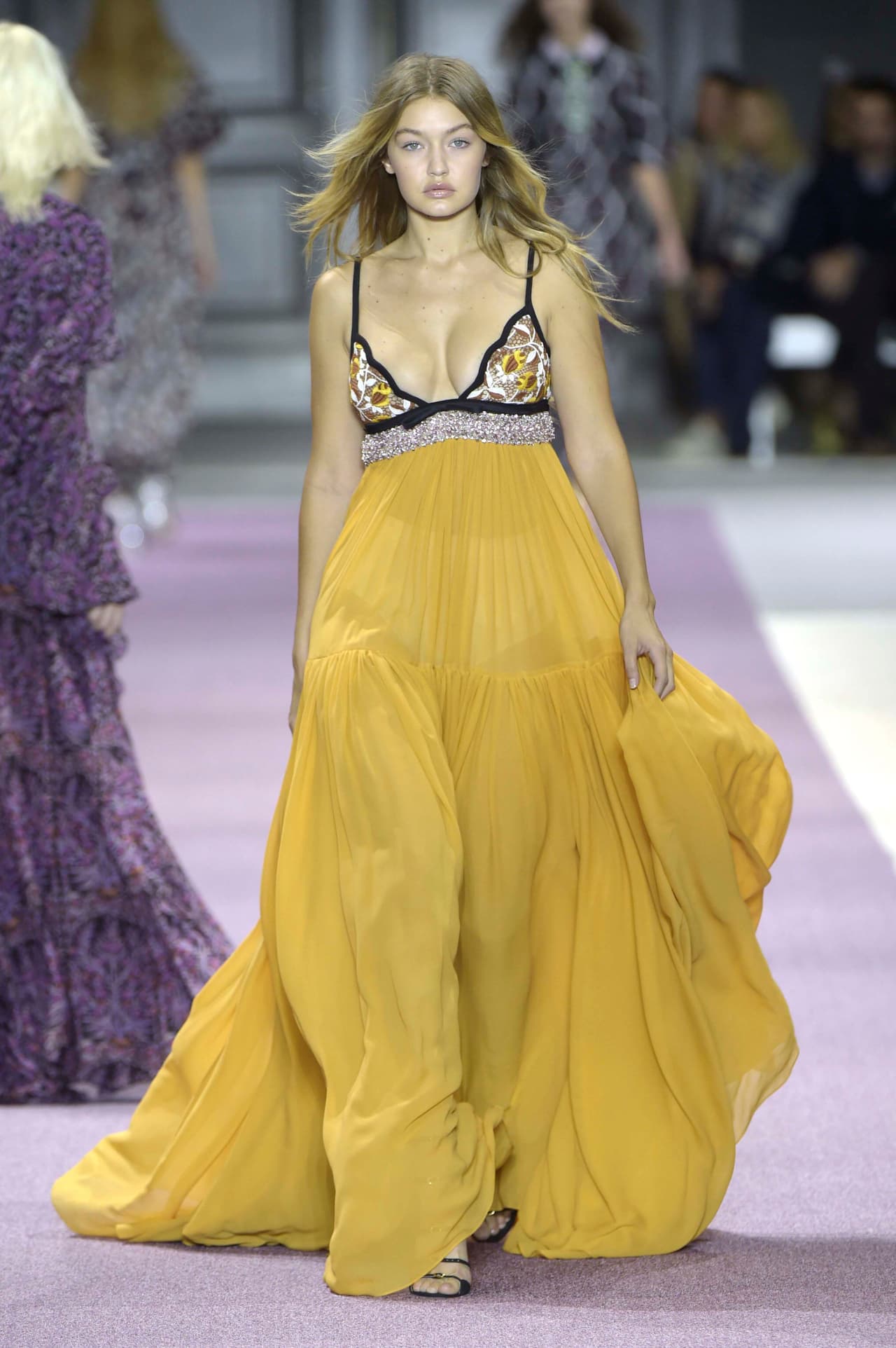 Luego de ser duramente criticada por algunos integrantes del mundo de la moda sobre las curvas de su cuerpo, Gigi se lució en un 'maxi dress' con cuello 'halter' y falda amplia amarilla del diseñador Giambatista Valli. ¡Checa cómo lució!