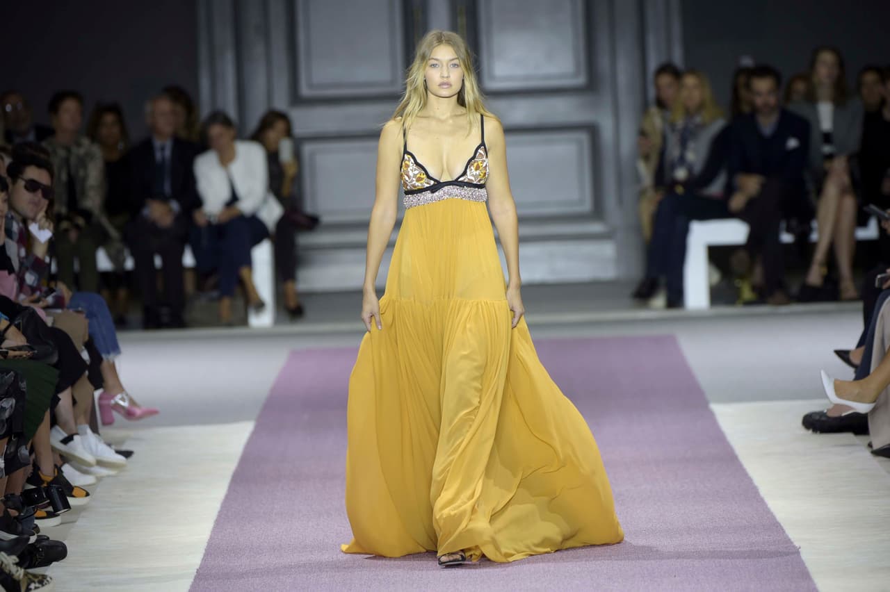 Luego de ser duramente criticada por algunos integrantes del mundo de la moda sobre las curvas de su cuerpo, Gigi se lució en un 'maxi dress' con cuello 'halter' y falda amplia amarilla del diseñador Giambatista Valli. ¡Checa cómo lució!