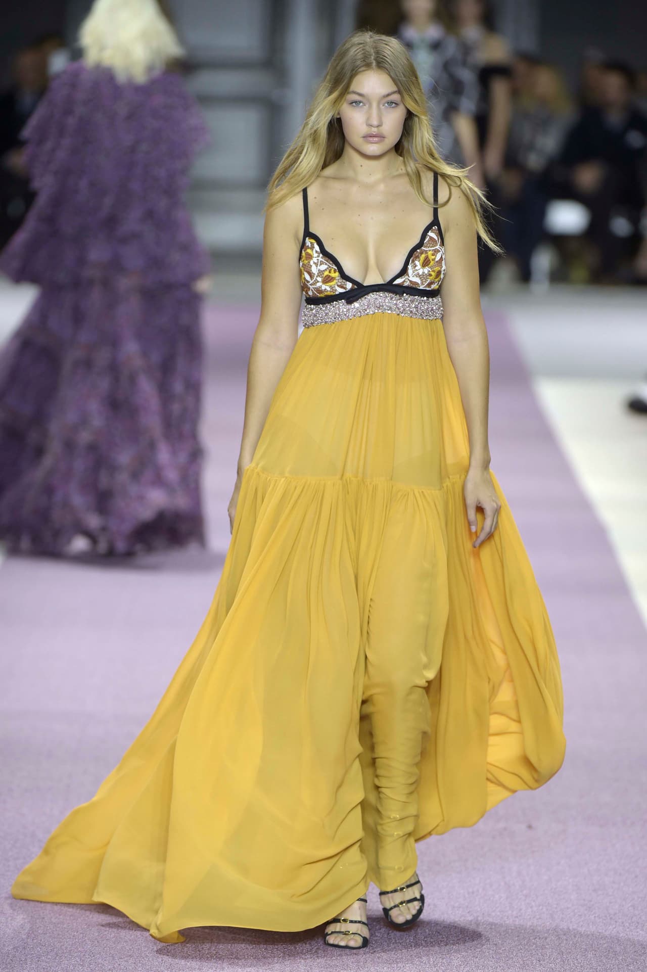 Luego de ser duramente criticada por algunos integrantes del mundo de la moda sobre las curvas de su cuerpo, Gigi se lució en un 'maxi dress' con cuello 'halter' y falda amplia amarilla del diseñador Giambatista Valli. ¡Checa cómo lució!