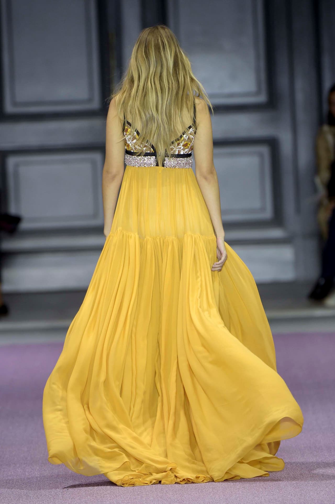 Luego de ser duramente criticada por algunos integrantes del mundo de la moda sobre las curvas de su cuerpo, Gigi se lució en un 'maxi dress' con cuello 'halter' y falda amplia amarilla del diseñador Giambatista Valli. ¡Checa cómo lució!