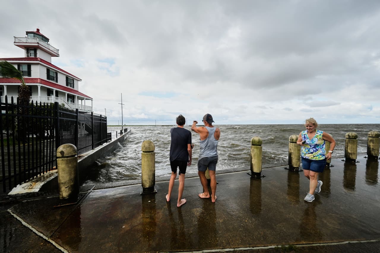 Varias personas observan una marejada ciclónica en Lakeshore Drive, a orillas del lago Pontchartrain, mientras la tormenta tropical Bertha se acerca a la costa de Luisiana el miércoles 22 de julio de 2026, en Nueva Orleans. (Foto AP/Gerald Herbert)