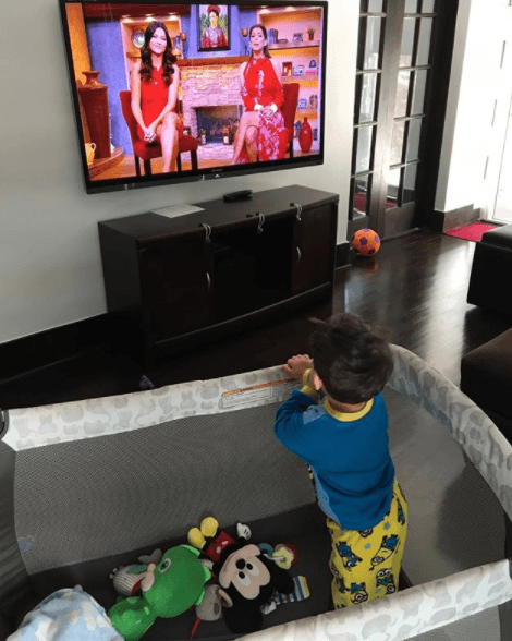 Muy atento siguiendo a mami en la televisión.