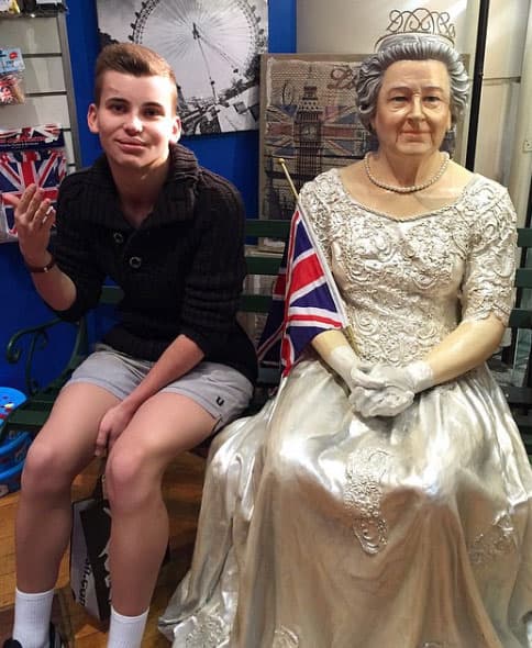 Aquí posando con una estatua de cera de la Reina Isabel II.