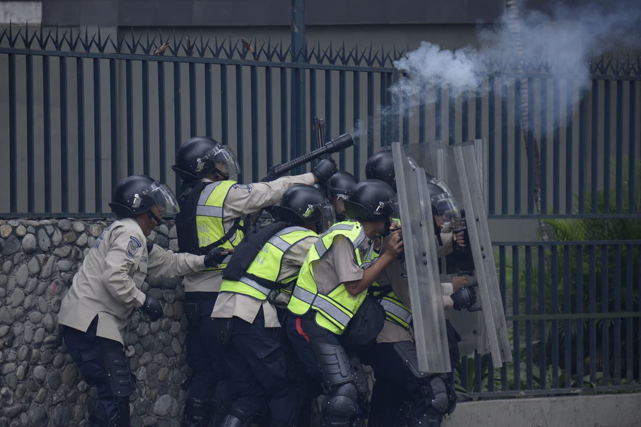 La policía dispara bombas lacrimógenas a la multitud reunida para protestar contra del nuevo decreto del presidente Maduro.