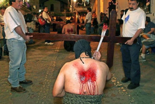 Con el torso desnudo, se autoflagelan durante la procesión por las calles coloniales de Taxco, Guerrero.