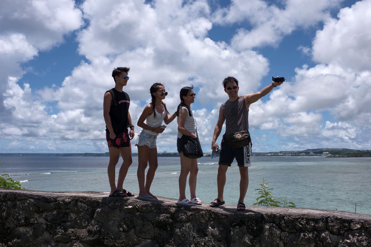 Una foto del 14 de agosto de 2017, en la que un grupo de turistas posan para una selfie en la capital de Guam, Hagatna. Según la oficina del gobernador dijo a la agencia AFP, aún no se prevén cambio en las cifras de turismo de la isla.