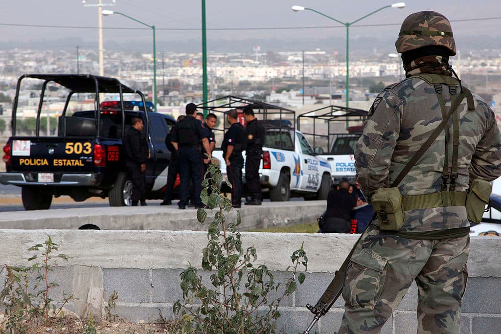 Personal del ejército mexicano vigilan cerca de policías arrestados del municipio García en el estado de Nuevo León, México, el 5 de noviembre de 2009.