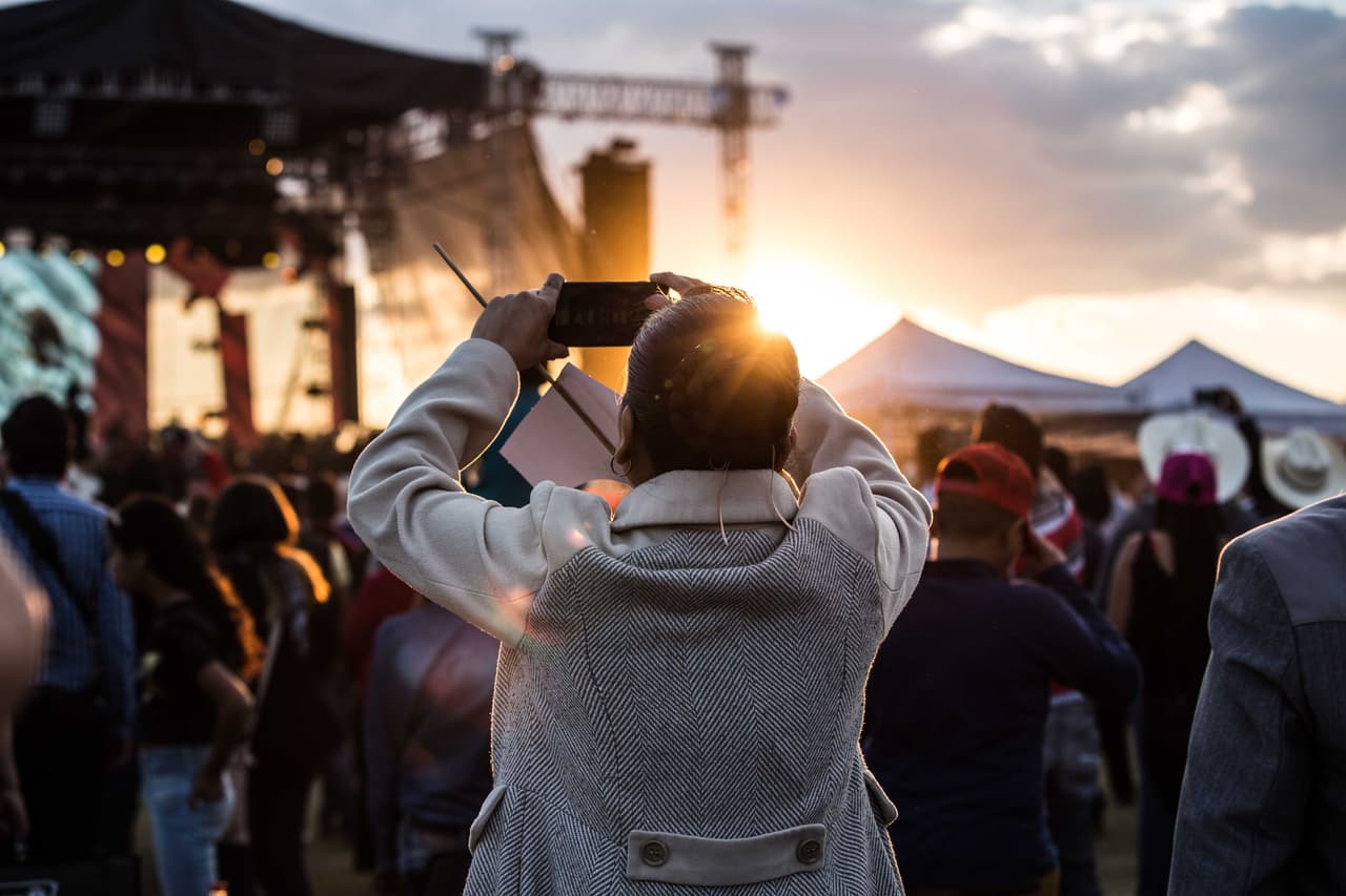 Una mujer toma una fotografía durante uno de los conciertos que amenizaron la multitudinaria fiesta.