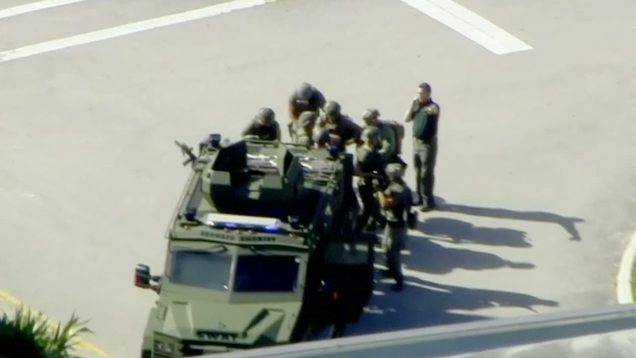 Autoridades armadas en el estacionamiento de la escuela. La policía advierte a las personas que eviten el área.