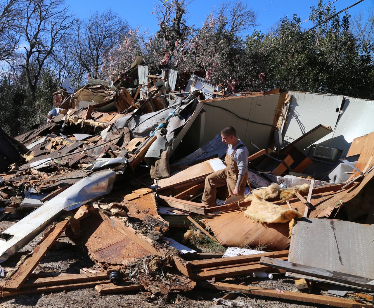 Jesse Gonzales examina los daños de su casa móvil en Texas.