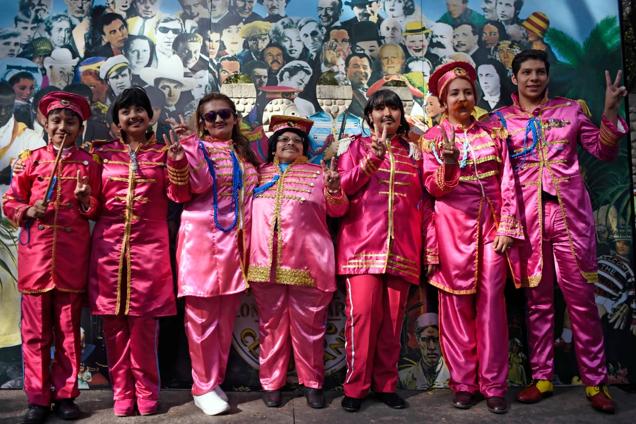 Un grupo caracterizado como The Beatles posa en el evento