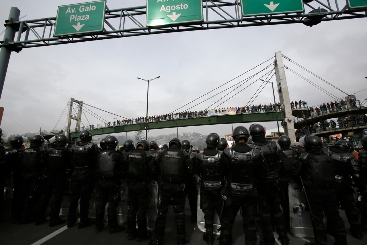 Policías con equipos antidisturbios se forman cuando los manifestantes cierran la carretera Panamericana durante una protesta contra la eliminación de los subsidios al combustible anunciada por el presidente Lenín Moreno, en Quito, Ecuador, el jueves 3 de octubre de 2019.