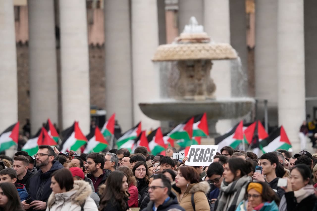 Banderas palestinas entre los fieles que se reúnen para escuchar al Papa Francisco pronunciar la bendición Urbi et Orbi (en latín, "a la ciudad y al mundo") del día de Navidad desde el balcón principal de la Basílica de San Pedro en el Vaticano, el lunes 25 de diciembre de 2023.