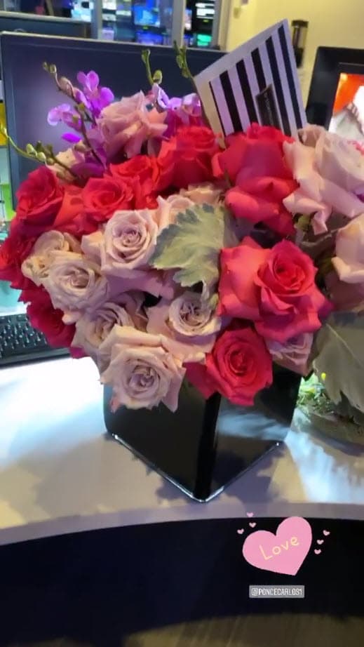 "Vean que flores, están bellas. Me las mandó..." e inmediatamente mostró la tarjeta que decía "Carlos".