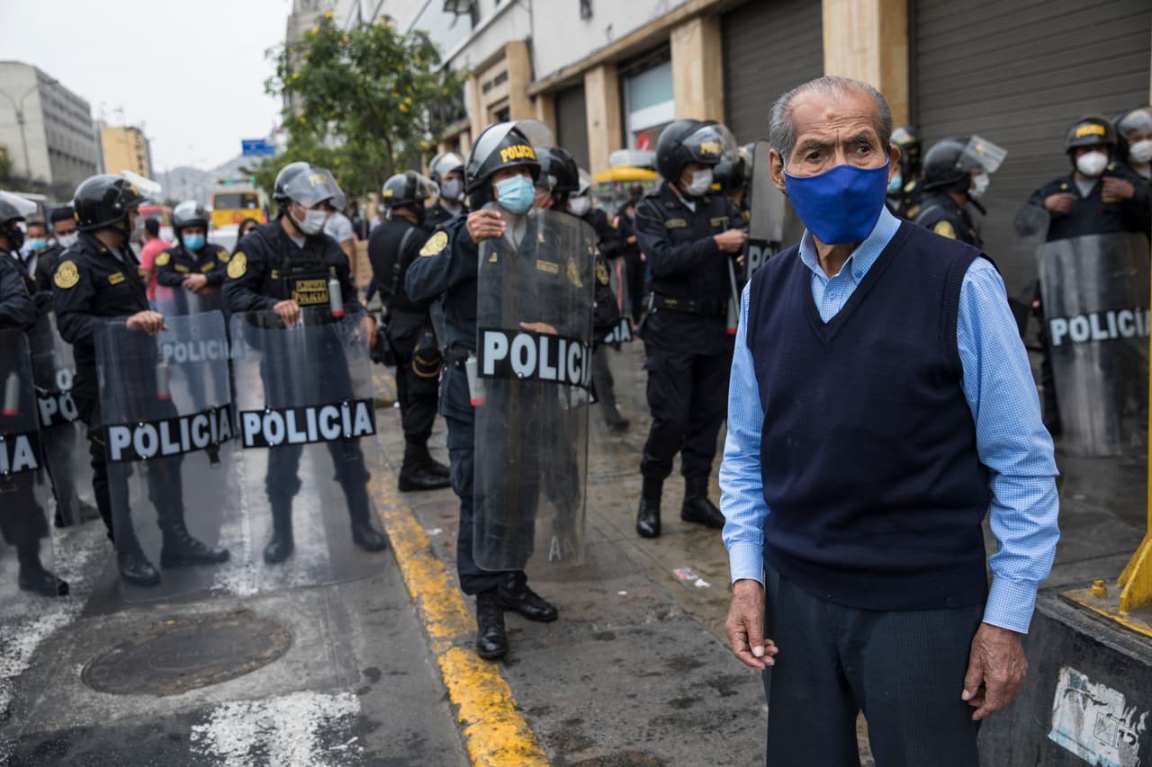 Un hombre cerca de la policía en los alrededores del Congreso en Lima, Perú, mientras usaba una máscara de protección en uno de los países más afectados por la pandemia en la región, con más de 920,000 contagios y casi 35,000 muertos.
