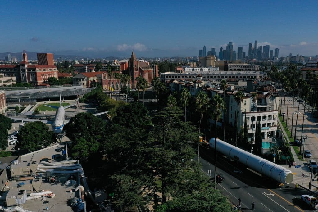Esta toma aérea muestra los enormes cilindros, Motores de Cohetes Sólidos para Transbordadores (SRM, por sus siglas en inglés) mientras eran transportados por la calle Figueroa, rumbo al Centro de Ciencias de California. Allí se encuentra el Endeavour, en posición horizontal.