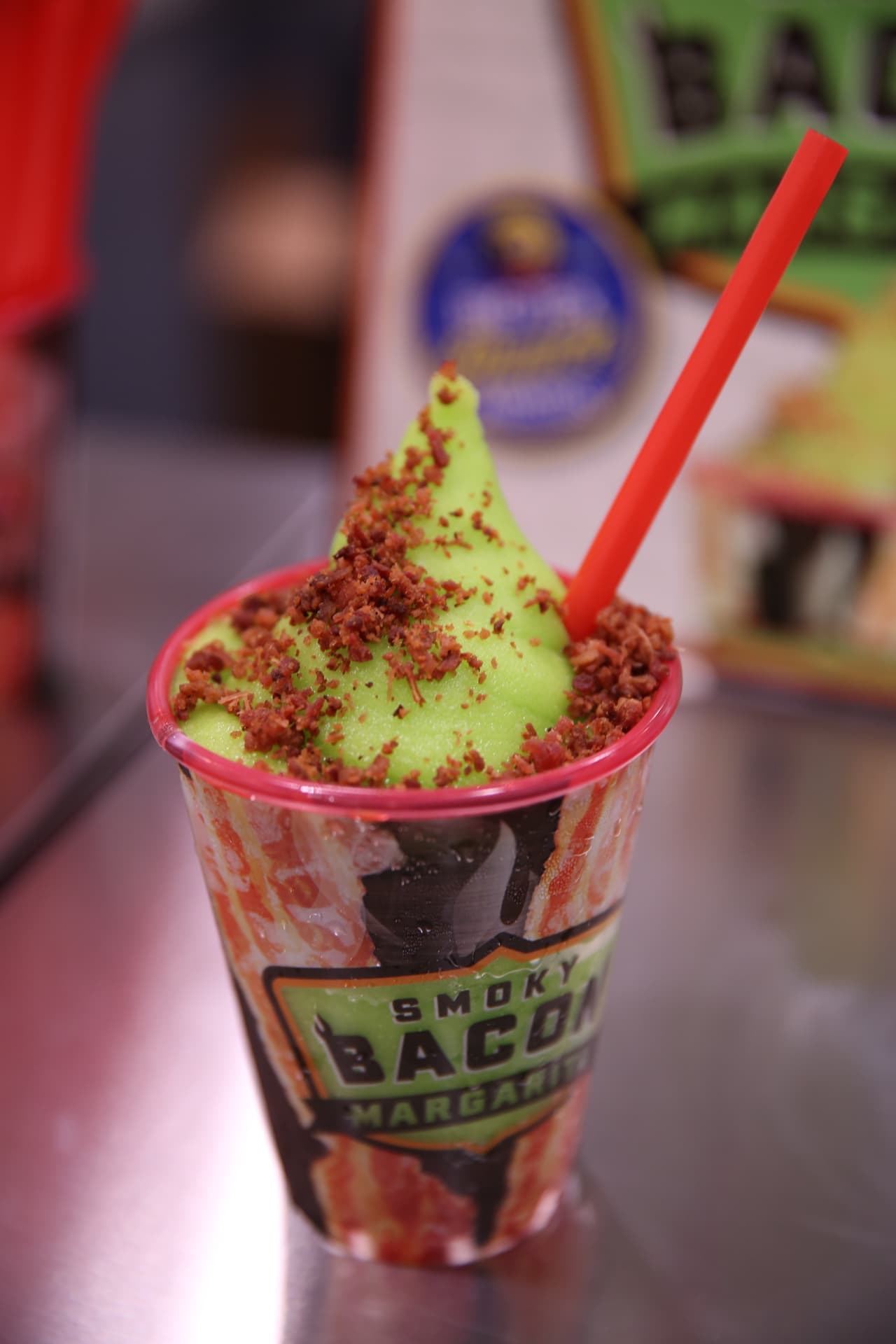 Con un toque de humo, esta bebida todavía captura el sabor cítrico picante de una margarita tradicional. Terminamos con una pizca de tocino se desmorona en la parte superior, esta bebida para saciar la sed se sirve en una taza de recuerdo de colección para un toque moderno añadido.