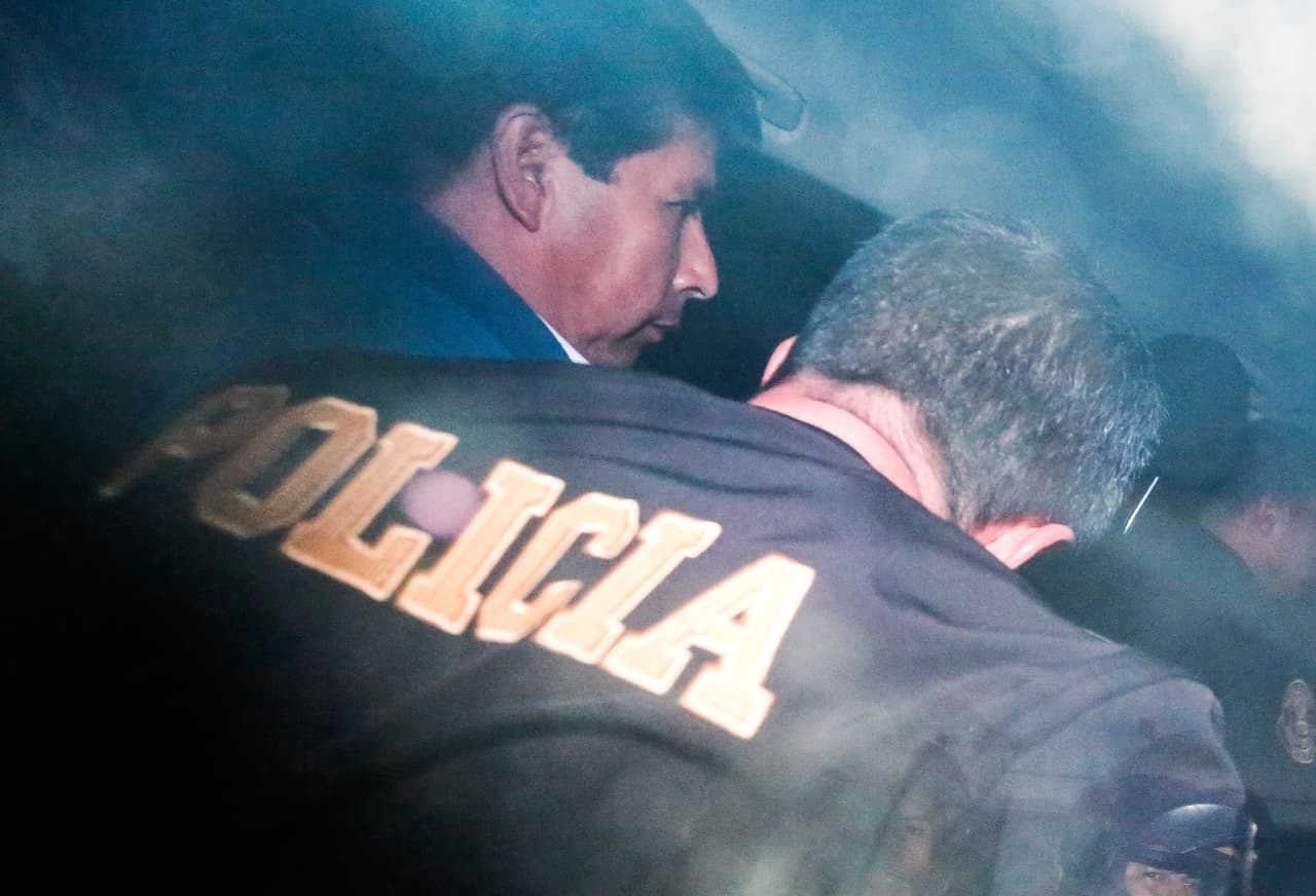 Pedro Castillo escoltado por policías en la prefectura de Lima el 7 de diciembre de 2022.