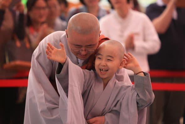 Este pequeño monje se pone sonriente junto a su líder.