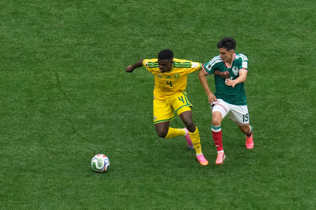 Teboho Mokoena, de Sudáfrica (izquierda), y Gilberto Mora, de México, disputan el balón durante el partido de fútbol del Grupo A de la Copa Mundial entre México y Sudáfrica en la Ciudad de México.