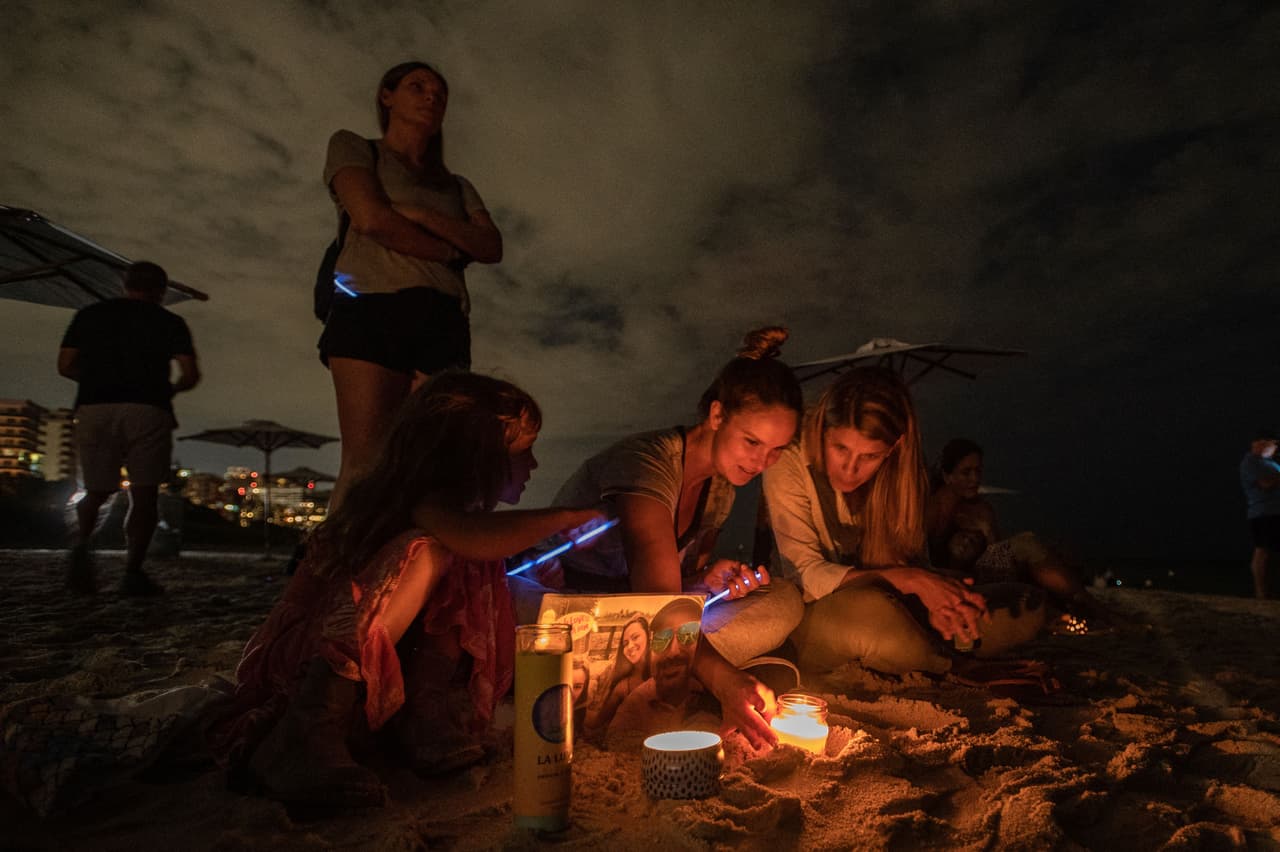 Con tierra y palitos fluorescentes, los asistentes a la vigilia escribieron en la arena la palabra "HOPE" (esperanza), mientras un poco más adelante, en las ruinas del edificio, se escuchaba el sonido de las herramientas de los socorristas aún durante la noche, sin señales de que recientemente se hubiera encontrado a alguien con vida.