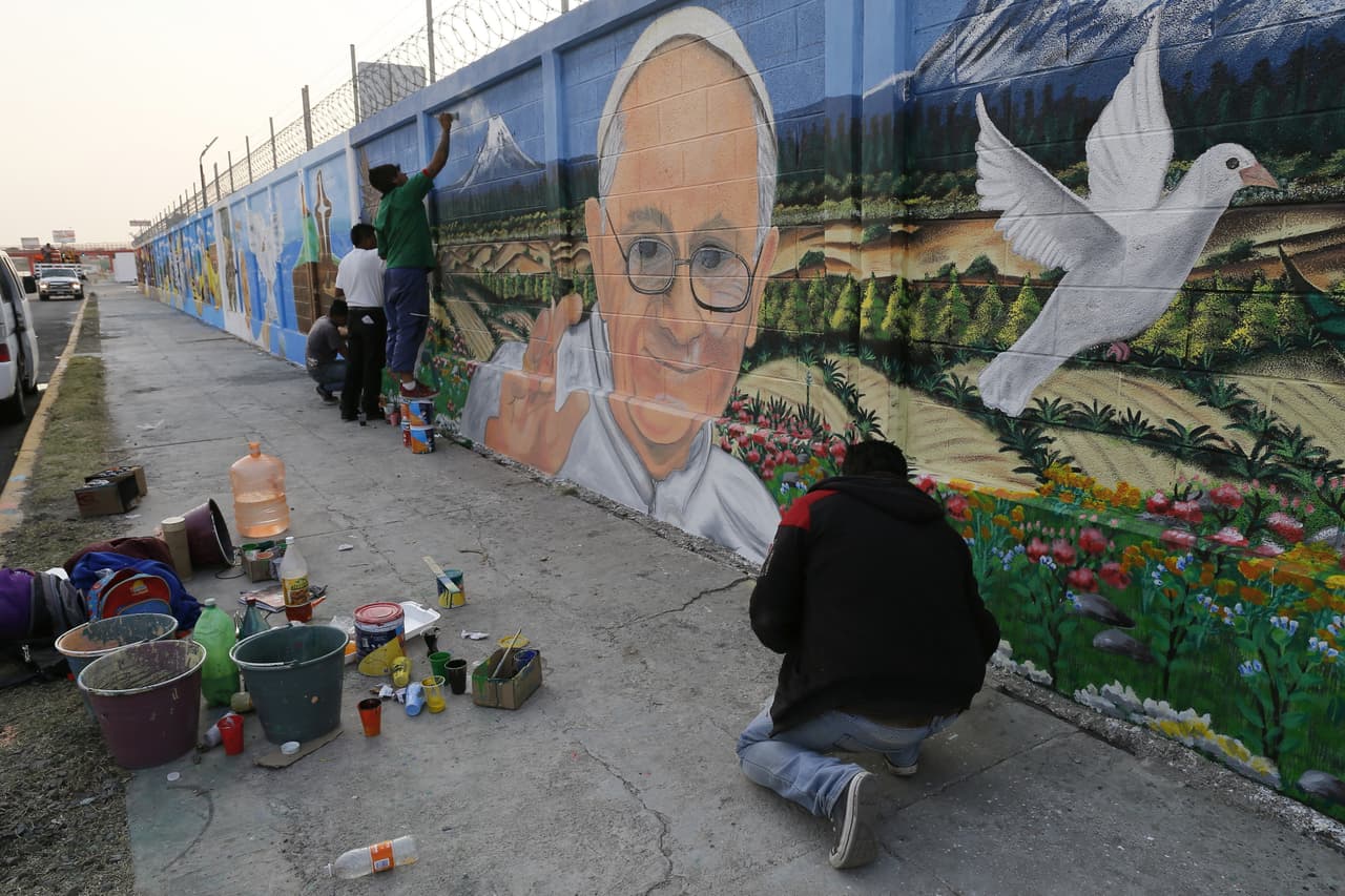 Un grupo de personas trabajan sobre uno de los murales en honor al papa Francisco en Ecatepec.