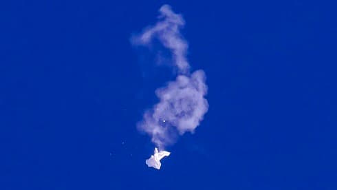 Fotografía proporcionada por Chad Fish de los restos del globo cayendo sobre el Océano Atlántico en la costa de Carolina del Sur, el sábado 4 de febrero de 2023. La inteligencia de EEUU espera recabar información clave de los restos del globo que le permita confirmar su versión de que, en efecto, se trata de un globo de vigilancia. Una de las razones por las que no fue derribado sobre tierra, además del peligro que representaba para zonas pobladas, es que su impacto en el océano permitió que no se destruyera completamente la evidencia que se pueda recolectar. (Chad Fish vía AP)