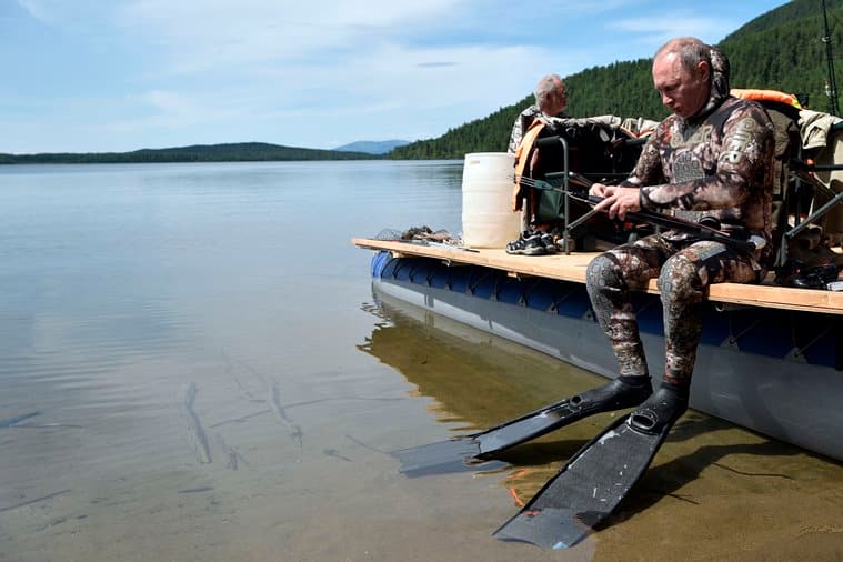 In this photo released by Kremlin press service on Saturday, Aug. 5, 2017, Russian President Vladimir Putin prepares for a swim during a mini-break in the Siberian Tyva region a few days ago. (Alexei Nikolsky, Sputnik, Kremlin Pool Photo via AP)