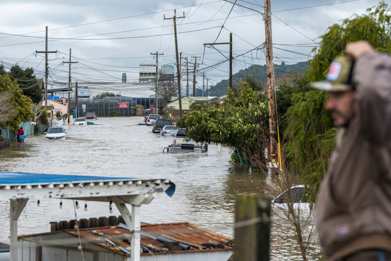 Un hombre observa las inundaciones en Watsonville, California, el sábado 11 de marzo de 2023.
