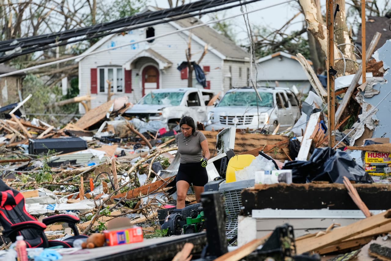 Una mujer camina entre los escombros después de que un tornado azotara Menasha, Wisconsin, el lunes 27 de julio de 2026.