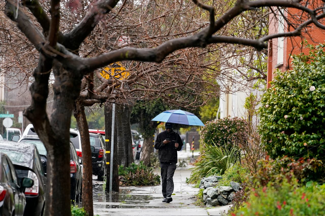 En el resto de la Bahía la tormenta invernal ha provocado fuertes lluvias acompañadas de vientos e incluso granizadas. En la imagen, un residente de Oakland se protege de la llovizna con su paraguas.
