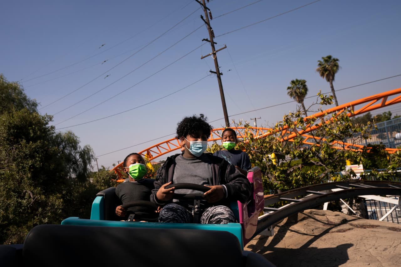 Visitantes en uno de los juegos mecánicos del parque Adventure City en su primer día de apertura tras pasar 403 días cerrado.
