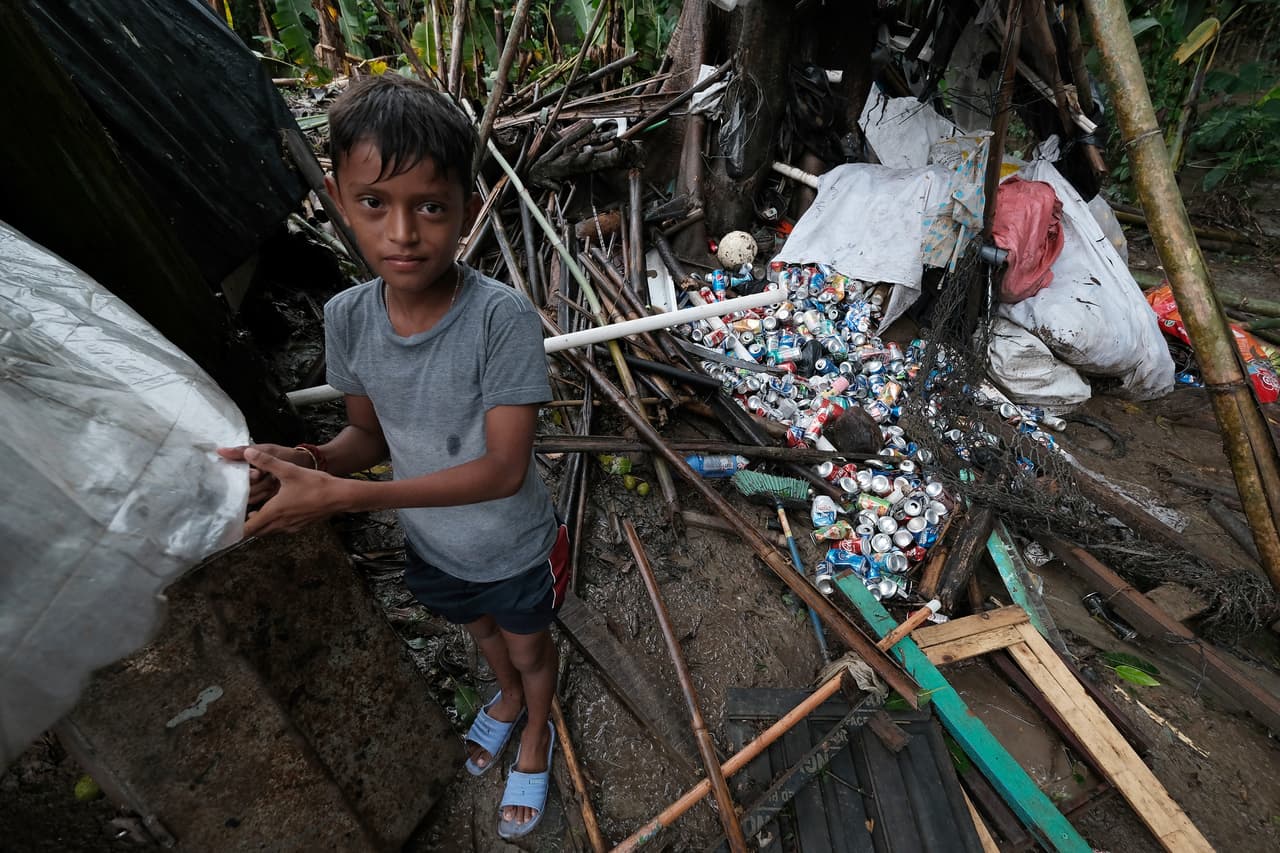Un niño ayuda a poner bolsas de plástico en las paredes y el techo de su casa para evitar que entre agua después del desbordamiento del río Lancetilla, en Tela, Honduras. 
<a href="https://www.univision.com/noticias/mundo/eta-toca-tierra-en-nicaragua-como-un-potente-huracan-categoria-4-y-con-lluvias-catastroficas-para-centroamerica">El huracán Eta embistió tierra</a> en Puerto Cabezas, Nicaragua, en la mañana de este martes.