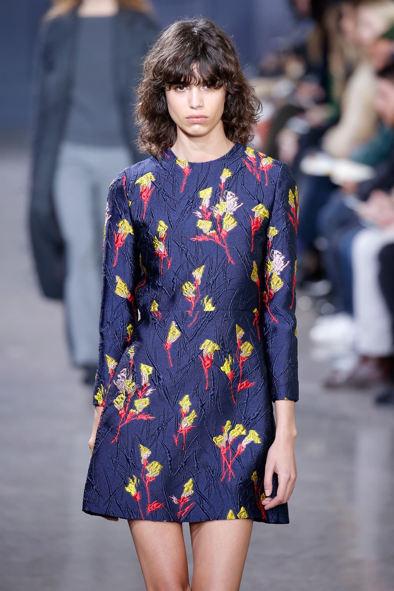 El traje de fondo azul bordado y flores amarillas fue presentado por Jason Wu en su pasarela Spring 2016. En su versión corta salió al mercado 
<a href="https://www.net-a-porter.com/us/en/product/751150?cm_mmc=LinkshareUS-_-J84DHJLQkR4-_-Custom-_-LinkBuilder&siteID=J84DHJLQkR4-GGVRBikgX9OjuvtOpMpSgg">por un valor de 1,995 dólares. Hoy se consigue en 998 dólares.</a>