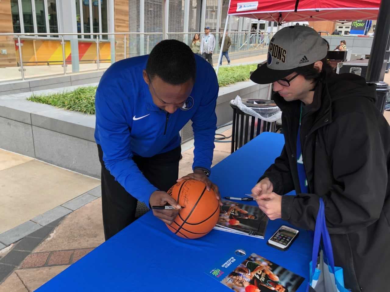 El legendario jugador Rolando Blackman estampa su firma en la bola de un fanático.