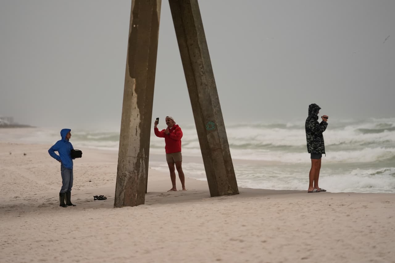 Varias personas filman las olas mientras el huracán Isaias se acerca a Pensacola Beach, Florida, el viernes 9 de octubre de 2026