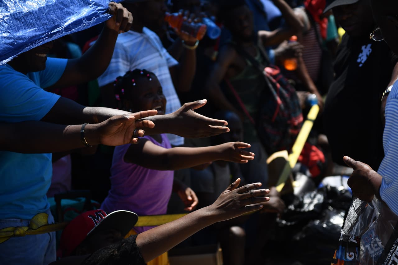 Las autoridades han solicitado a los residentes cuyas casas estaban intactas que se abrieran a las personas desplazadas por la tormenta. En la fotografía, tomada el 7 de septiembre de 2019, un grupo de bahameños espera por agua mientras hacen fila para ser evacuados en un muelle de Marsh Harbour.