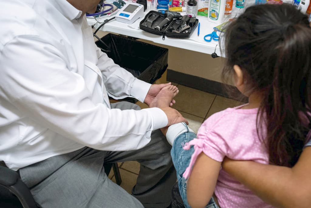 De la Rosa examina una erupción en las piernas de Meliza, de 5 años. Aunque podía tratarse solo de una erupción alérgica, los moretones pordían indicar algo más serio.
<br>