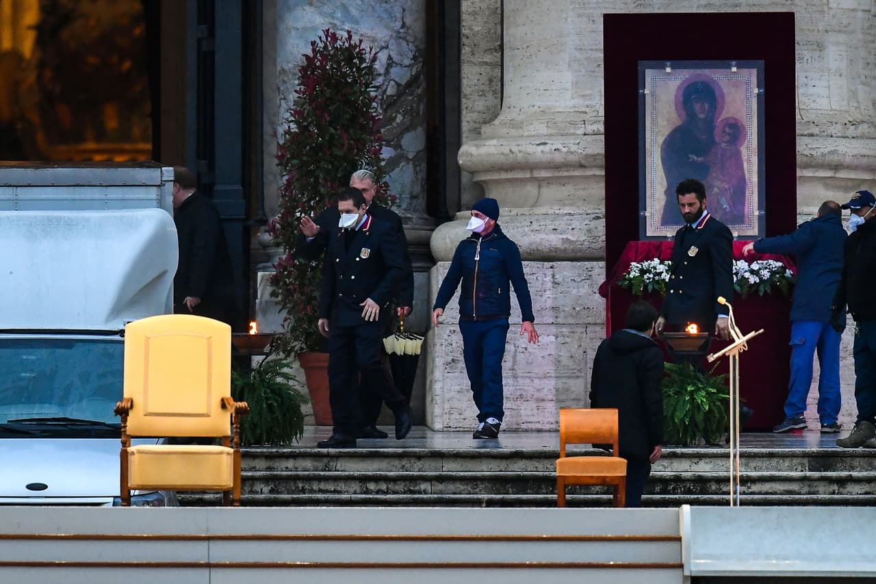 Los trabajadores, algunos con una máscara facial, terminan de instalar el escenario antes de que el Papa presida el momento de oración. La ceremonia sin precedentes comenzó a las 6:00 PM, cuando el papa se dirigió en silencio desde las escaleras de la plaza vaticana hacia el sagrado, desde donde ofreció la homilía.